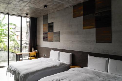 a bedroom with two beds and a large window at YZ SPA House in Jiaoxi