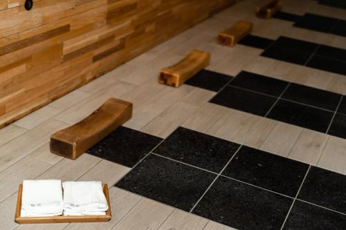 two wooden stools on a floor with black mats at YZ SPA House in Jiaoxi