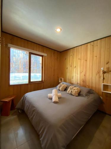 a bedroom with a large bed with a window at Cabañas Koyam Ruka in Licán Ray