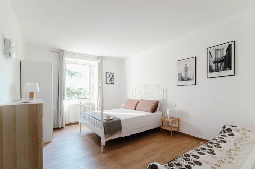 una camera bianca con un letto e una finestra di Villa Bertacchi - inside and out Como a Como