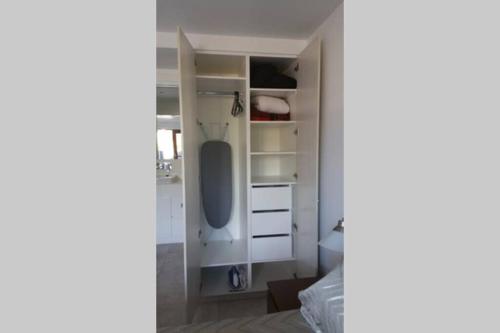 a bedroom with white cabinets and a bed at Woolloongabba, comfortable, modern, private studio in Brisbane
