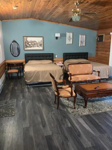 a bedroom with two beds and a table and chairs at Alpine Inn in Valemount