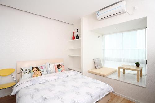 a white bedroom with a bed and a window at Homy Inns Mu Ma in Nanjing