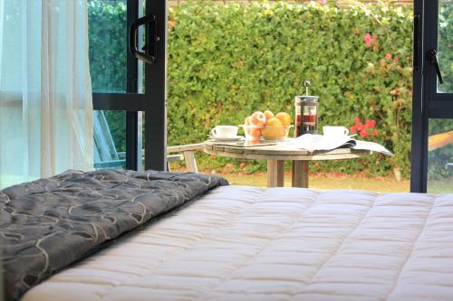 a bed and a table with a plate of fruit at Waves in Orewa