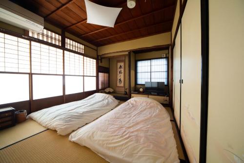 uma cama grande num quarto com duas janelas em 阿美弥 一日一組様限定 em Quioto