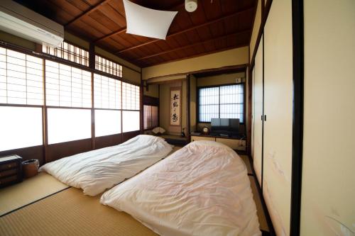 a large bed in a room with two windows at 阿美弥 一日一組様限定 in Kyoto