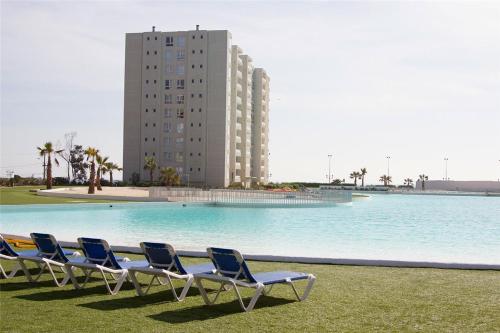 a group of chairs sitting in front of a swimming pool at Departamento en Papudo Laguna in Papudo