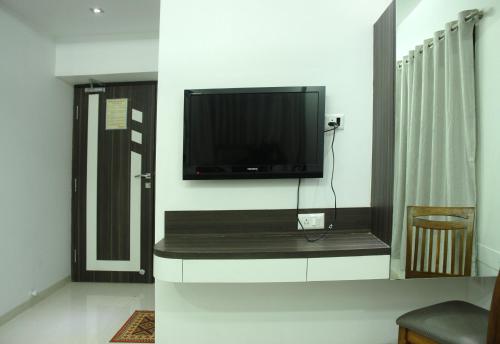 a living room with a flat screen tv on the wall at Hotel City View in Navi Mumbai