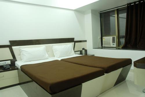 a bedroom with a large bed with a window at Hotel City View in Navi Mumbai