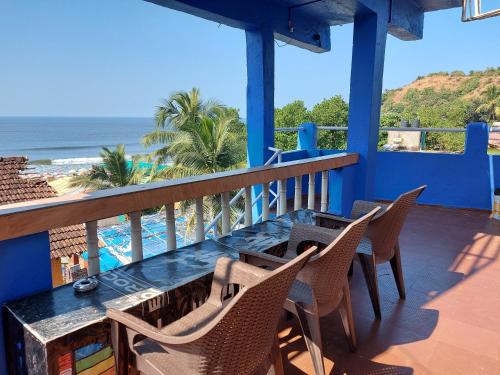a balcony with a table and chairs and the ocean at Red Rock Arambol Beach in Arambol