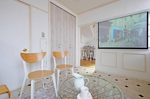 a living room with two chairs and a flat screen tv at Meee Shinjuku in Tokyo