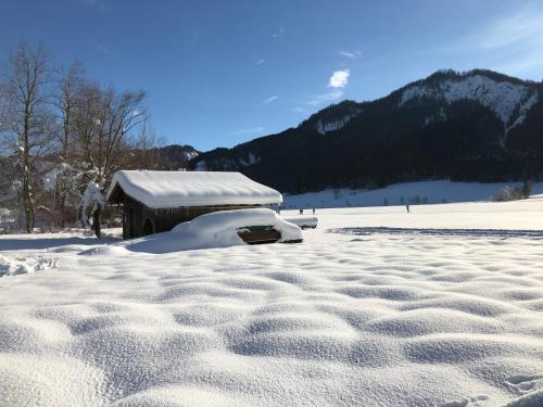 a snow covered yard with a building in the background at Hotel Berghof in Berg im Drautal