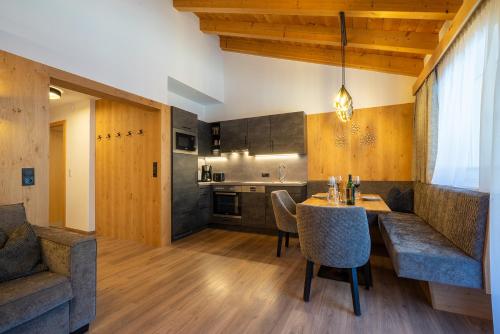 a kitchen and living room with a table and chairs at MAXAlpin Appartements in Längenfeld