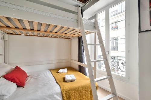 une chambre avec un lit superposé et une échelle dans l'établissement Lovely Mezzanine Studio in the Heart of Paris 3M, à Paris