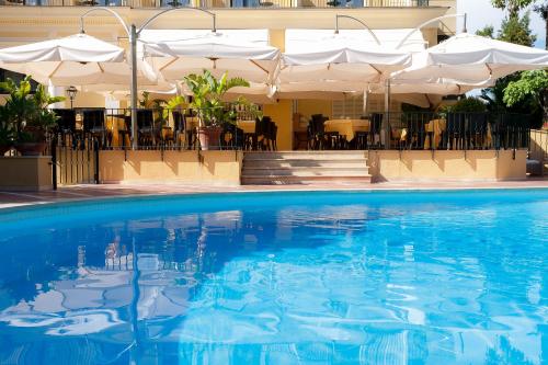 a swimming pool with blue water in front of a hotel at Imperial Hotel Tramontano in Sorrento