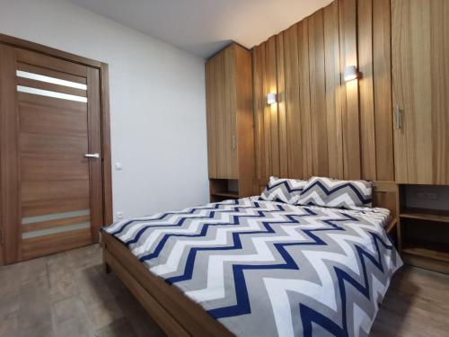 a bedroom with a large bed and a wooden cabinet at Green Apartments in Chernihiv