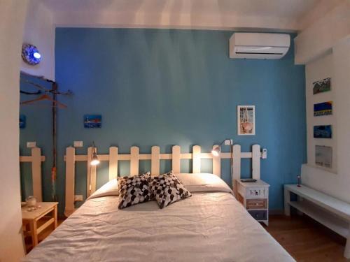 una camera con un letto con una parete blu di CASE VACANZE ZADA SIRACUSA a Siracusa