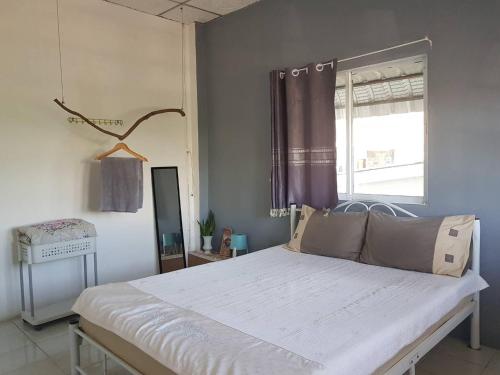 - une chambre avec un grand lit blanc et une fenêtre dans l'établissement Take A Rest At Nakhon Phanom, à Nakhon Phanom