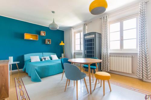 a blue bedroom with a bed and a table and chairs at Le Camere Pietrasantine - Centro Storico in Pietrasanta