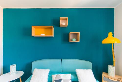 a blue wall with a blue couch in a room at Le Camere Pietrasantine - Centro Storico in Pietrasanta