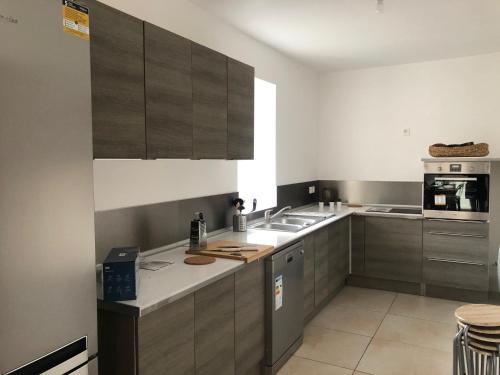 a kitchen with stainless steel appliances and gray cabinets at Les gîtes de Machault in Machault