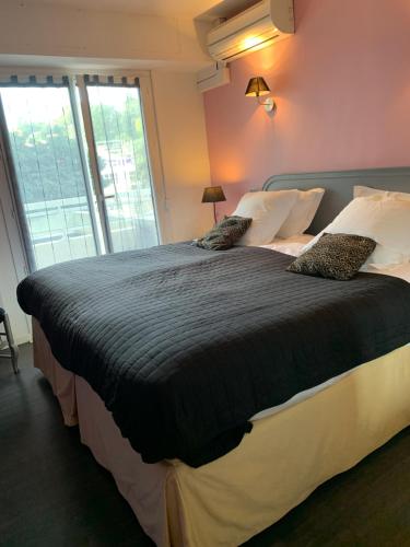 una camera da letto con un grande letto con due cuscini di APPART' CANNES a Cannes