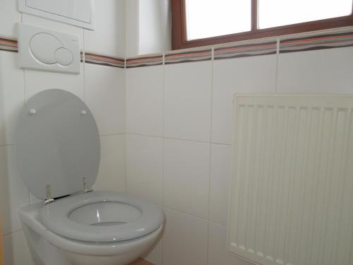a white bathroom with a toilet and a window at Apartmán Mocca in Kašperské Hory
