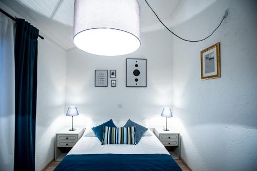 1 dormitorio con 1 cama con sábanas azules y 2 lámparas en Beach Suite Nina, en Rab