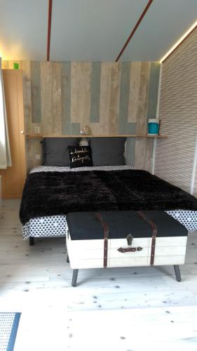 a bedroom with a large bed with a black blanket at le haut village Chambre d'hôtes Mobi-Loft cosy sauna ,douche ,chromothérapie in Arrest