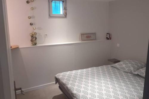 - une chambre avec un lit et une fenêtre sur le mur dans l'établissement Logement entier 4 personnes Villefranche sur Saone, à Villefranche-sur-Saône
