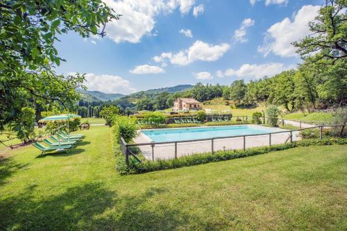 una piscina in un cortile con sedie e una casa di Cerqua Rosara Residence a Valtopina