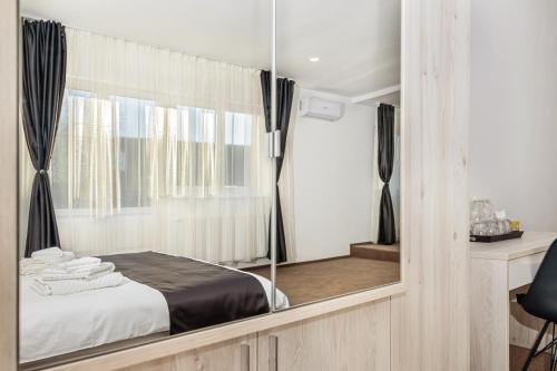 a bedroom with a bed and a mirror at Bada Bing Residence in Braşov