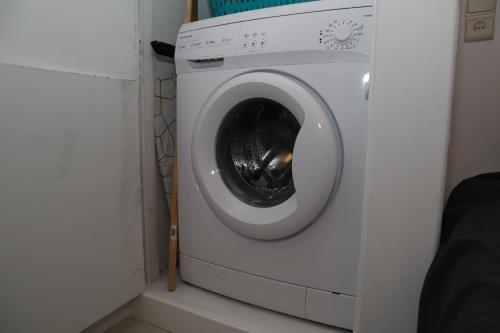 a white washing machine in a corner of a room at Modern appartement met uniek zeezicht in Koksijde