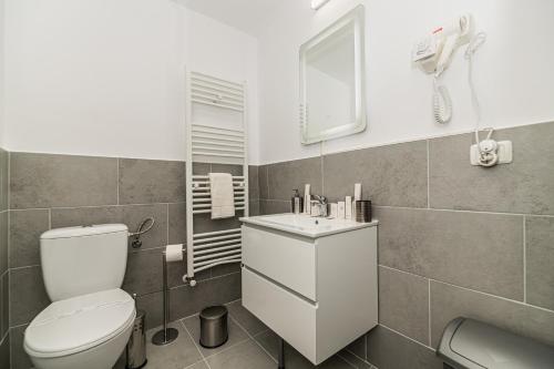 a bathroom with a white toilet and a sink at Bada Bing Residence in Braşov