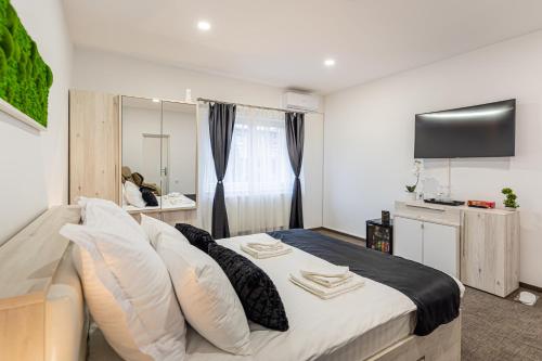 a bedroom with a large bed and a television at Bada Bing Residence in Braşov