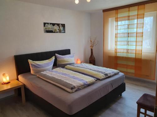 ein Bett mit zwei Kissen darauf in einem Schlafzimmer in der Unterkunft Ferienwohnung Vikolisa in Bad Schonborn