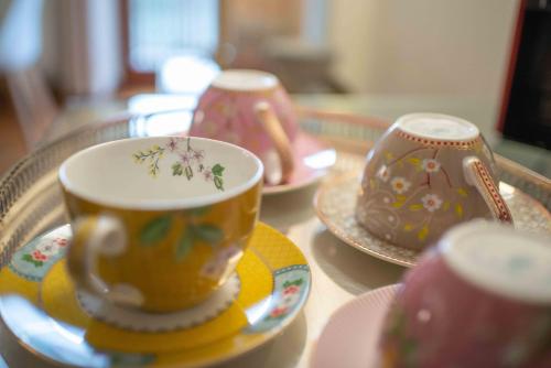 três xícaras e pires em uma mesa de vidro em 3 Amici al Castello em Verona