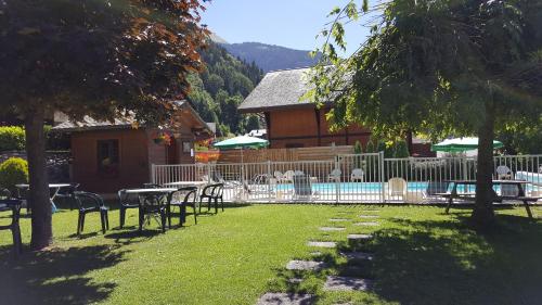 a yard with tables and chairs and a swimming pool at Résidence Julianna , trajets remontées mécaniques , livraison viennoiseries, piscine couverte in Morzine