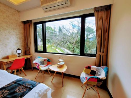 a bedroom with a bed and chairs and a window at 山水奇異San Shuei Kiwi桃園市民宿編號038 Homestay in Sanmin