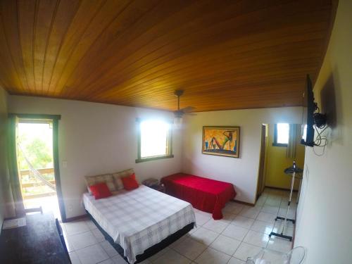 a bedroom with a bed and a red couch at Topo do Cipó Ecopousada Vegana in Serra do Cipo