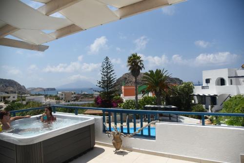 a woman in a hot tub on the balcony of a house at Popi Studios in Arkasa