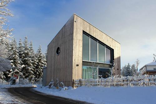 a house in the snow with a fence at Apartment Monolith Black Forest in Schonach
