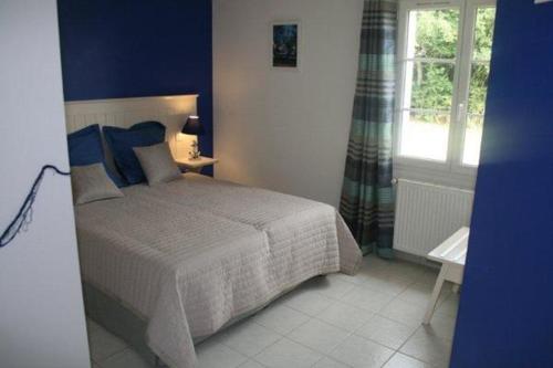 une chambre bleue avec un lit et une fenêtre dans l'établissement La Doucinière, à Polignac