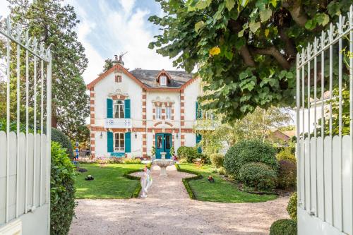 an open gate to a house with a garden at L'Oustal in Bourges