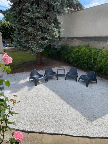 a group of chairs sitting on the ground next to a bench at Manoir 1838 à - 3 km du Zoo de Beauval & proche des châteaux in Saint-Aignan
