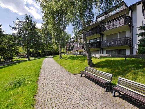 een park met twee banken voor een gebouw bij Ferienwohnung Nelly am Kurpark in Willingen