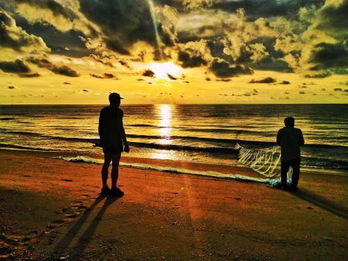 two people standing on the beach watching the sunset at Khanom Beach Residence Monthly Rental Condo in Khanom