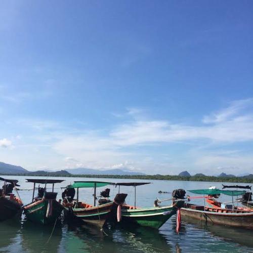 a group of boats sitting in the water at Khanom Beach Residence Monthly Rental Condo in Khanom