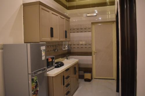 a kitchen with a refrigerator and a sink at دوز للشقق المخدومة in Najran