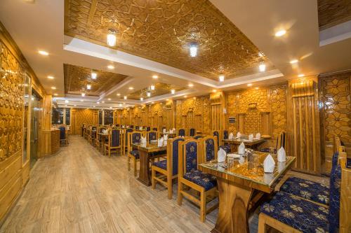 un ristorante con pareti e tavoli in legno e sedie di OPERA INN a Srinagar